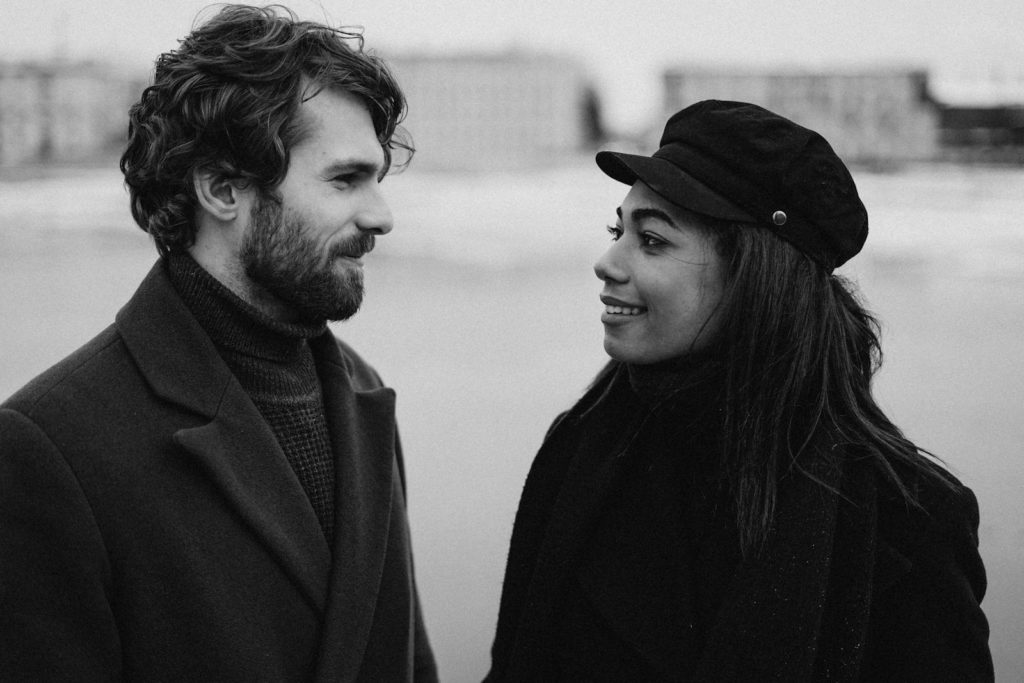 A couple sharing a loving moment in a black and white portrait outdoors.