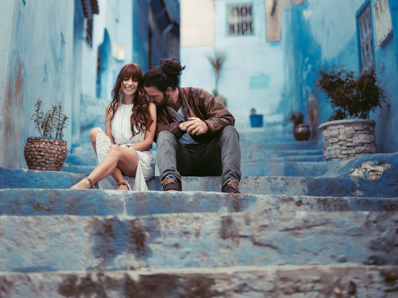 A couple enjoys a romantic moment in the iconic blue streets of Chefchaouen, Morocco.