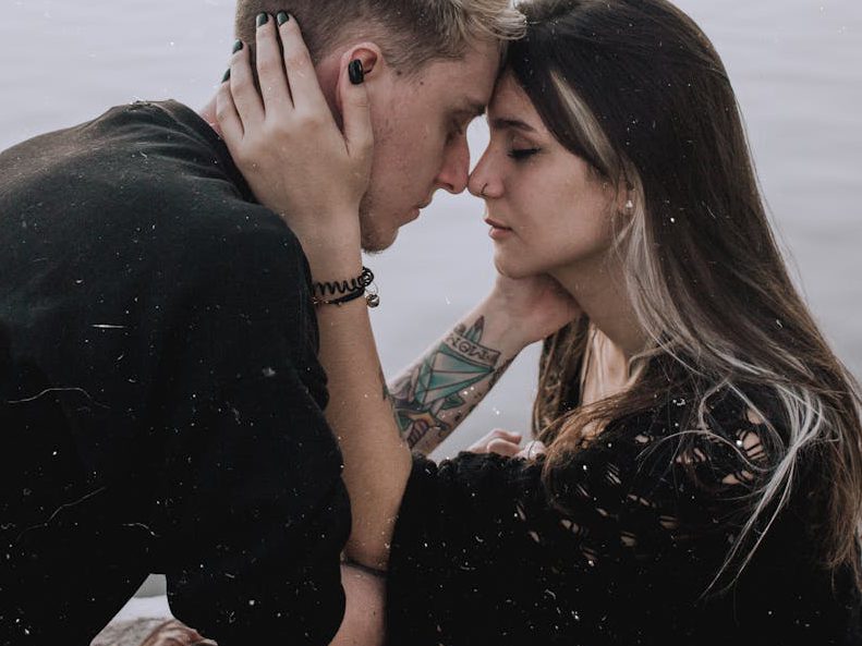 Young couple embracing by the waterside in Rio de Janeiro, capturing a serene and romantic moment.